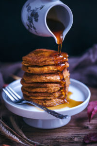 vegan pumpkin pancakes with maple syrup and walnuts